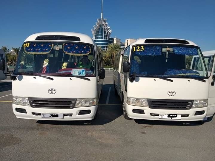 Two Toyota Coaster buses ready for the daily staff pick and drop in Dubai